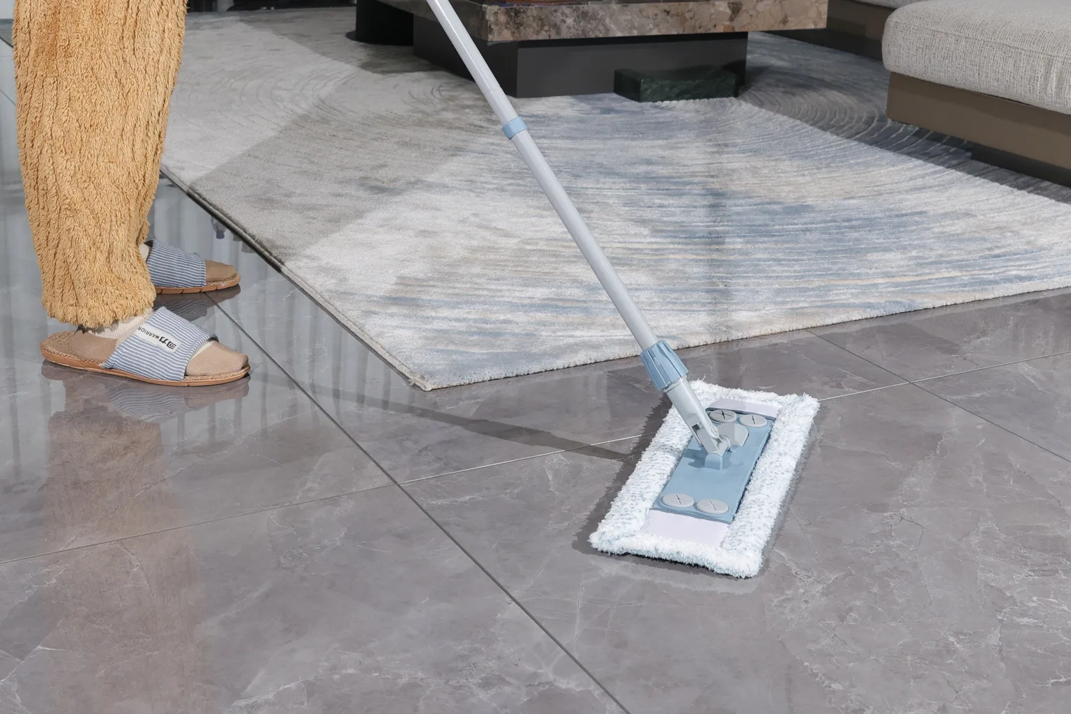 A flat mop being used on a tiled floor